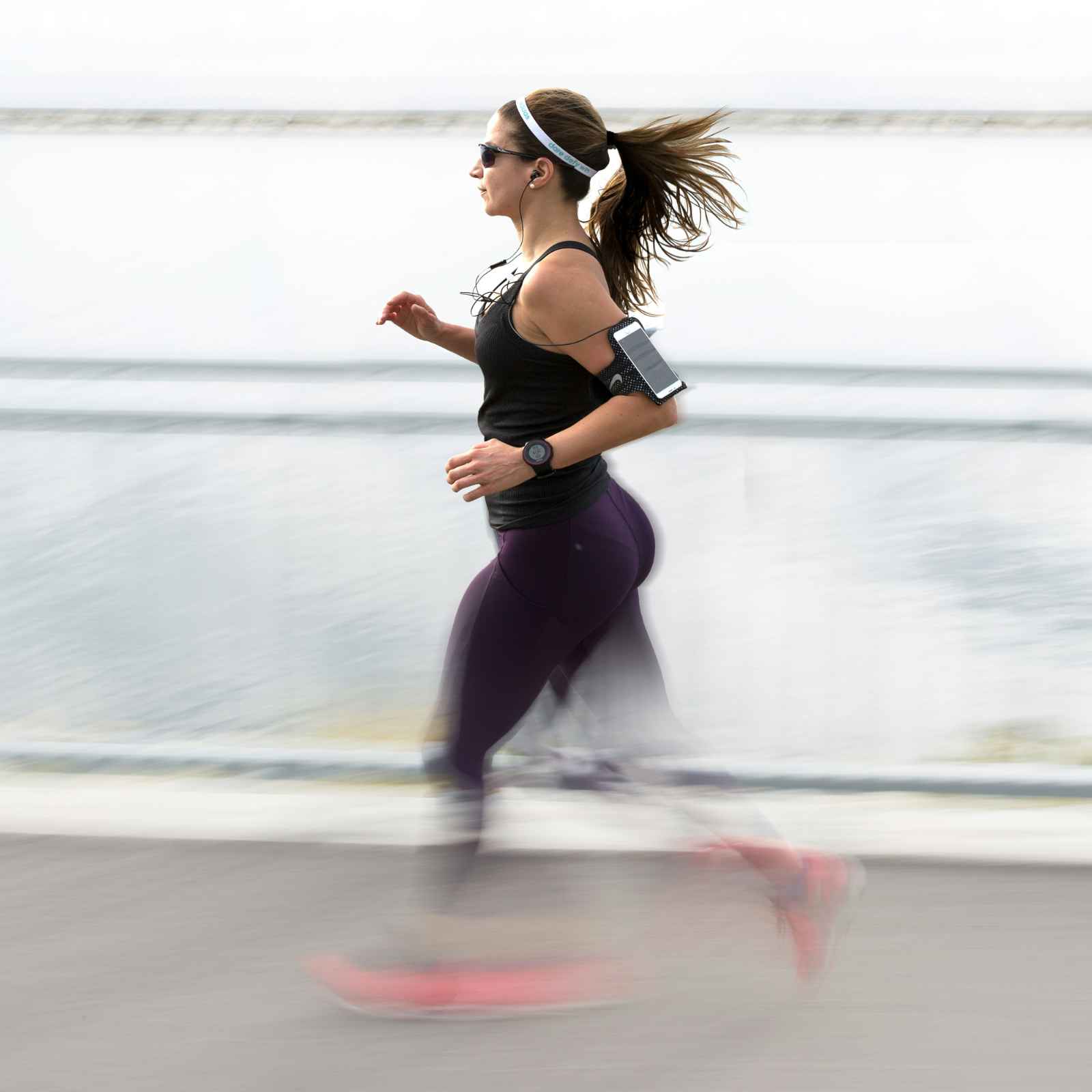 Vrouw loopt hard met activity tracker apps. Buiten sporten